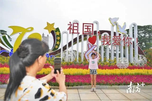 東湖廣場(chǎng)花卉組景前,萌娃們擺出愛(ài)心動(dòng)作拍照留念。 南方+ 楊興樂(lè) 拍攝 圖片