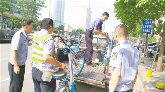 蓬江區(qū)聯(lián)合執(zhí)法大隊對亂停放的共享單車作暫扣處理。