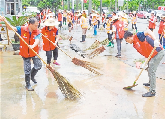 大雨過(guò)后，水浸過(guò)的路面積滿黃泥和雜物，大批義工利用休息時(shí)間清理蓬江區(qū)建設(shè)路的淤泥與雜物。
