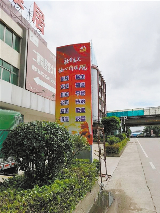 一家房地產企業(yè)請來廣告公司，把門前戶外廣告牌改造為社會主義核心價值觀宣傳牌。李千帆攝